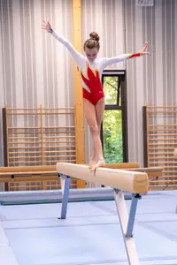 Eine Turnerin der Turngemeinde Landshut balanciert konzentriert auf dem Schwebebalken in der Sporthalle.