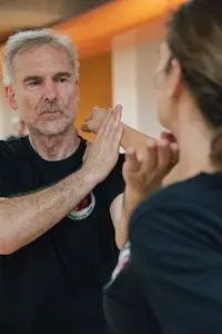 Zwei Personen üben Selbstverteidigungstechniken in einem Kurs der Turngemeinde Landshut.