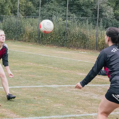 Zwei Spielerinnen der Turngemeinde Landshut konzentrieren sich beim Faustballspiel auf dem Sportplatz.