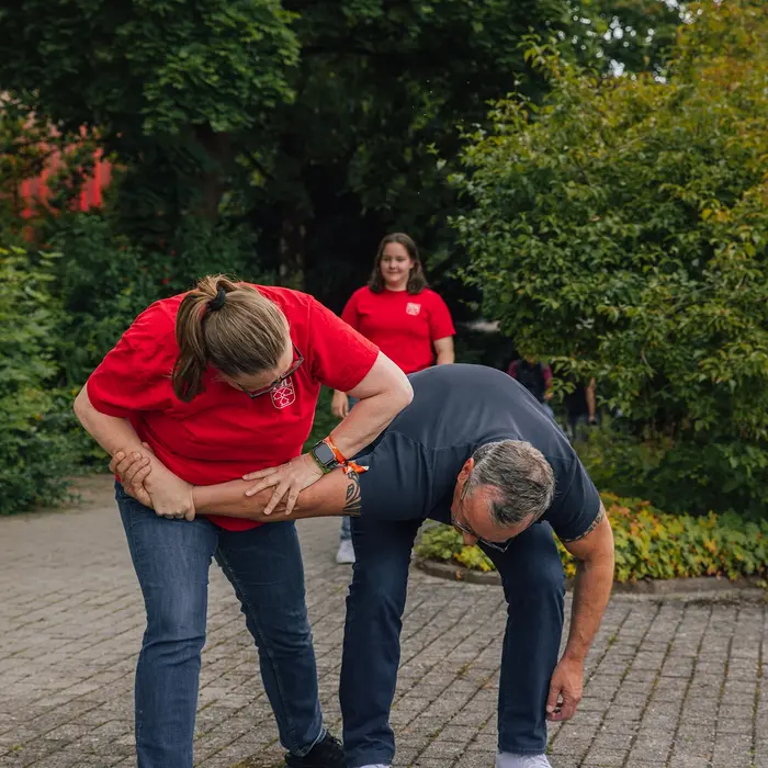 Zwei Personen üben Selbstverteidigungstechniken im Freien bei einem Event der Turngemeinde Landshut.