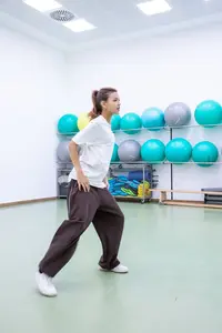 Eine Frau trainiert in einem Sportraum der Turngemeinde Landshut vor bunten Gymnastikbällen.