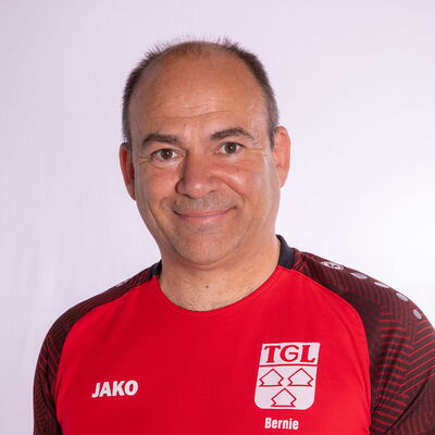 Ein Mann im roten TGL-Trikot lächelt freundlich in die Kamera, repräsentierend den Sportverein Turngemeinde Landshut.