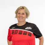 Eine lächelnde Frau im TGL-Sporttrikot steht vor einem neutralen Hintergrund.