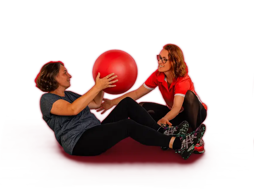 Zwei Frauen trainieren lächelnd mit einem Gymnastikball im Rahmen des Seniorensports beim Sportverein Turngemeinde Landshut.