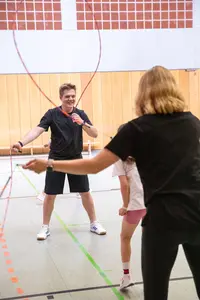 Eine Gruppe springt in einer Turnhalle mit Seilen, organisiert von der Turngemeinde Landshut.