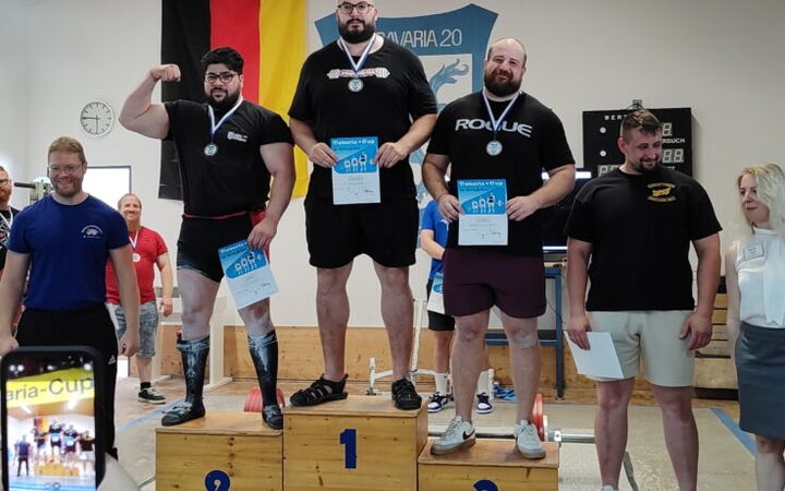 Drei Athleten stehen stolz auf dem Siegerpodest beim Maria-Cup, organisiert von einem Sportverein in Landshut.