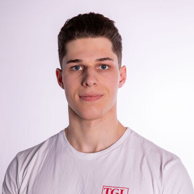 Ein junger Mann im weißen TGL-Trainer-Shirt repräsentiert stolz den Sportverein Turngemeinde Landshut.