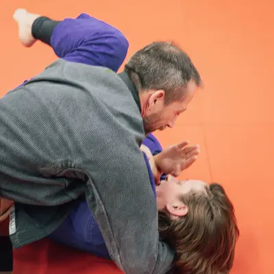 Zwei Männer trainieren Judo auf einer roten Matte bei der Turngemeinde Landshut im Sportverein.