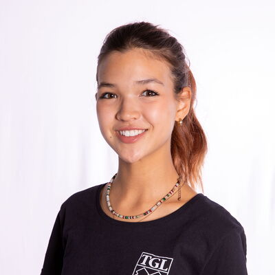 Eine lächelnde Frau im TGL-T-Shirt repräsentiert stolz ihren Sportverein.