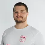 Ein Trainer der Turngemeinde Landshut trägt ein T-Shirt mit dem TGL-Logo und schaut direkt in die Kamera.