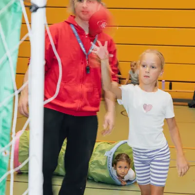 Ein Mädchen wirft einen Ball in einer Turnhalle des Turnvereins Landshut, während ein anderes Kind im Tunnel spielt.