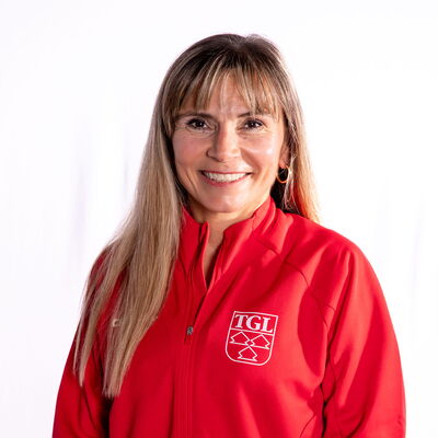 Eine lächelnde Frau trägt eine rote TGL-Jacke, symbolisierend den Sportgeist des Vereins Turngemeinde Landshut.