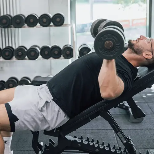 Ein Mann trainiert mit Hanteln auf einer Schrägbank im Fitnessstudio des Turnvereins Landshut.