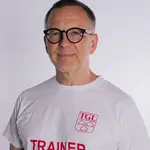 Ein lächelnder Mann trägt ein TGL-Shirt, mit dem Aufdruck Trainer.
