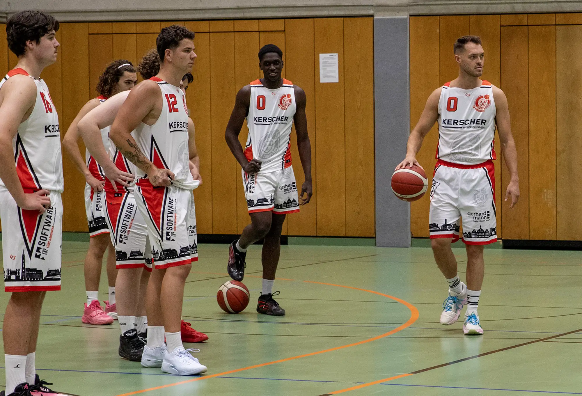 Eine Gruppe von Sportlern der Turngemeinde Landshut trainiert gemeinsam auf einem grünen Sportplatz.