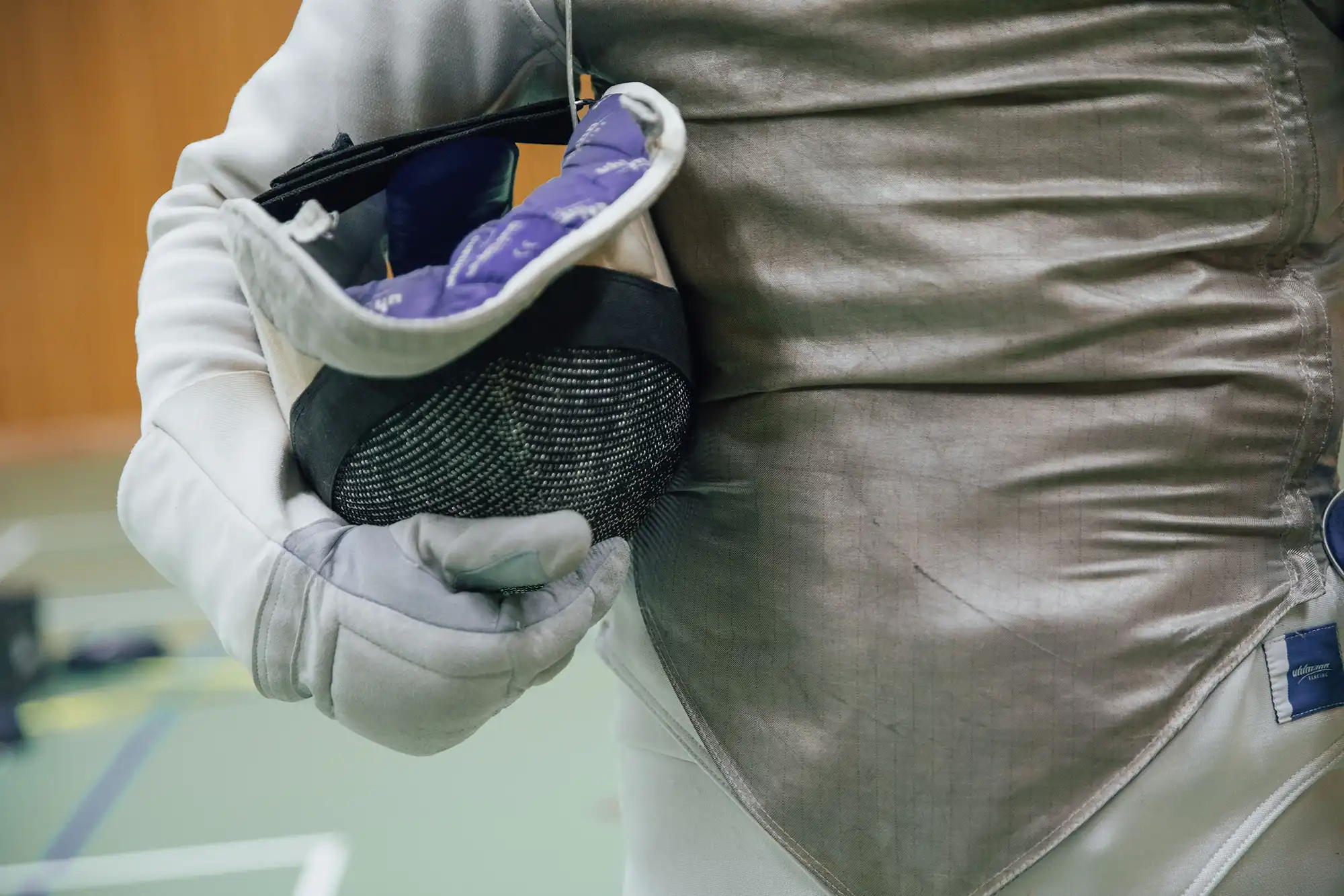 Ein Fechter hält seine Maske in der Hand, bereit für das Training beim Sportverein Turngemeinde Landshut.